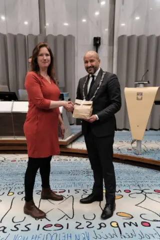 Eva van Esch schudt burgemeester Marcouch de hand.